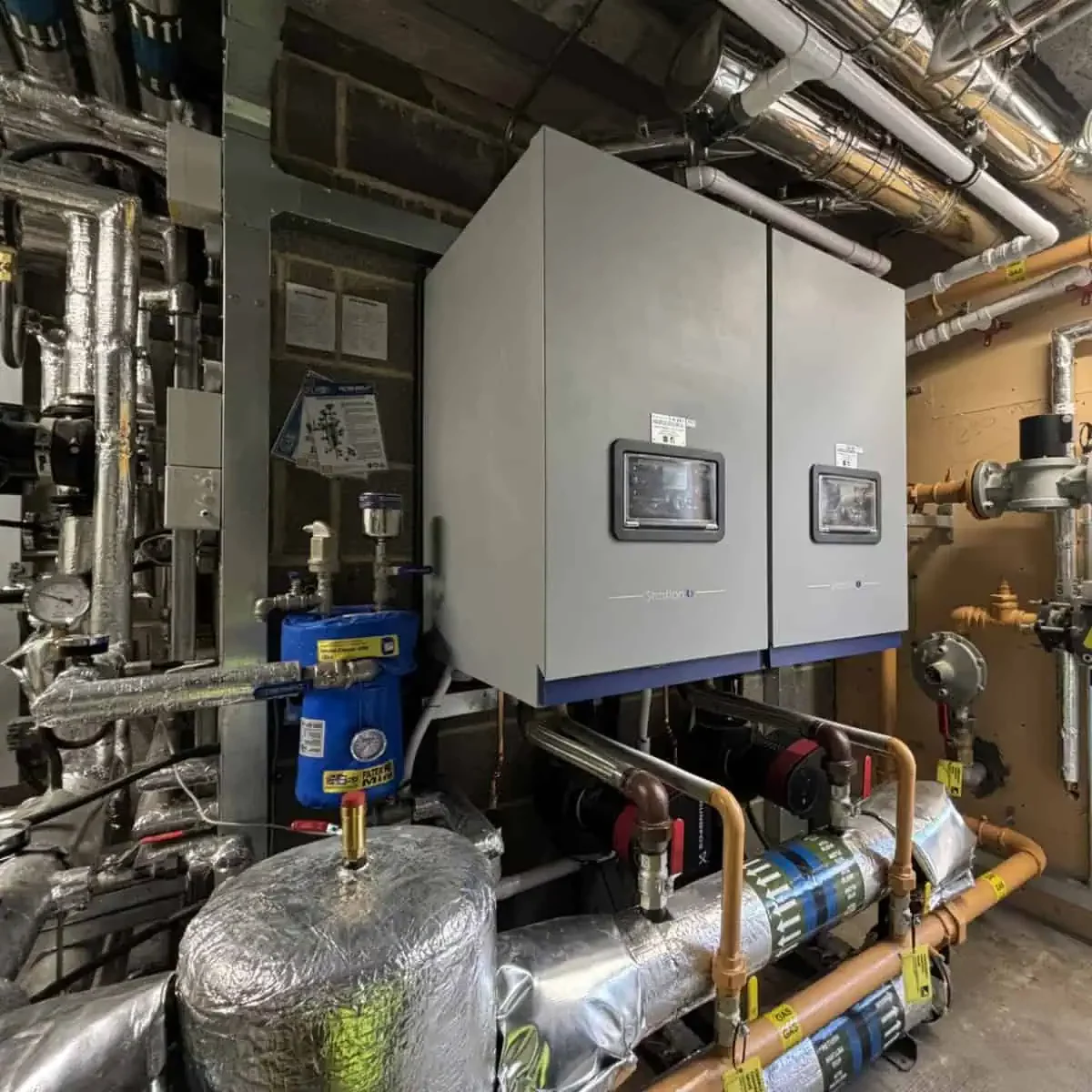 R-M-Myers-Heating-Plumbing-North-East-2025-02 Industrial heating system with pipes and control panels.